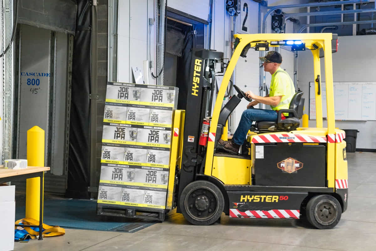 forklift removing boxes from dock truck